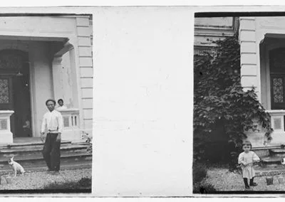 Homme, enfant et chien devant une maison, s.d.